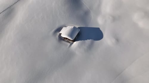 Aerial View of Cabin in Snowy Mountain Landscape