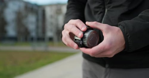 Nahaufnahme kaukasischer Hände legt seine Videoausrüstung ab: Fokusmodul
