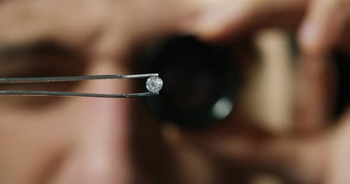 Inspecting a Diamond With Jeweler's Loupe Close Up