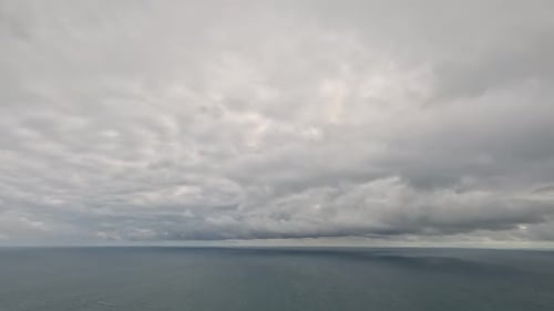 Timelapse of Dark Rain Clouds Moving in Overcast Grey Sky Over a Sea Horizon During Bad Weather