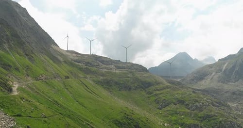 Grimsel Pass Mountain Road With Wind Turbines At Background In Bernese Alps, Switzerland. Aerial