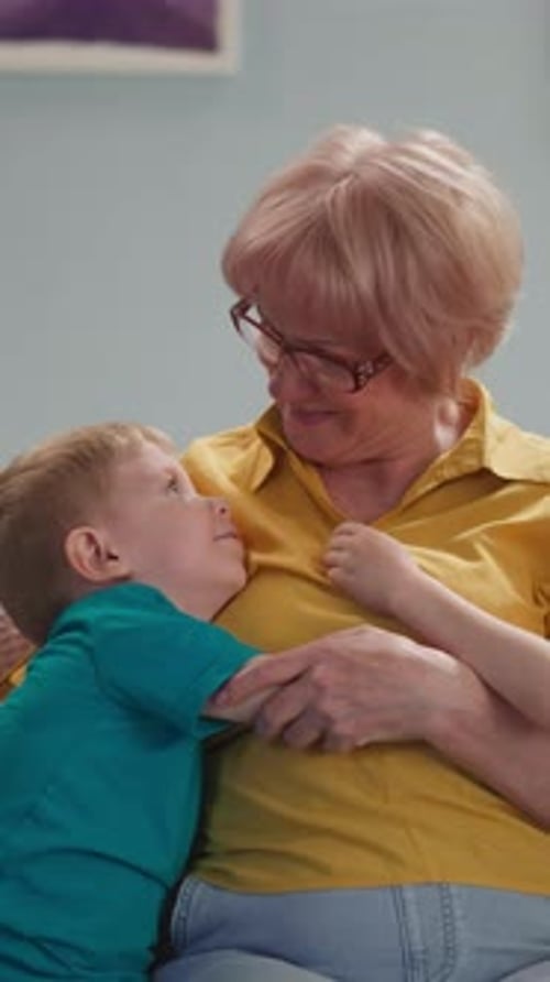 Loving Grandmother Hugs Young Grandson Affectionately Indoors