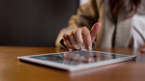 Frau, die auf dem Tablet-Bildschirm nach oben wischt, Nahaufnahme