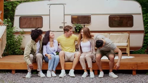 Friends Laughing and Bonding by Trailer Camper