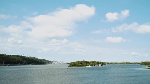 The Beautiful River Dnipro is Surrounded By Green and Fresh Vegetation in the City White Clouds on