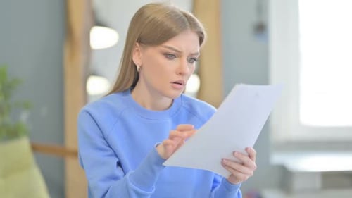 Worried Young Woman Reviews Documents