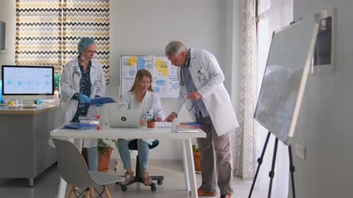Doctors Collaborating on Research During Meeting in Clinic Office