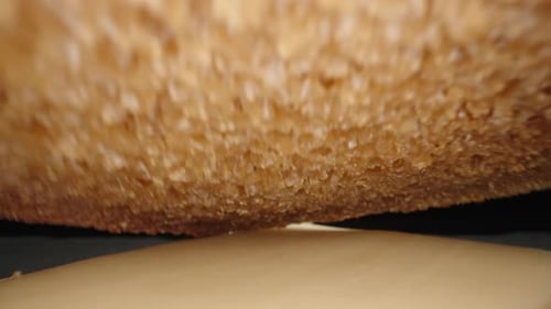 I'm making a sandwich.I put a piece of bread on the finished sandwich. Dolly slider extreme close-up