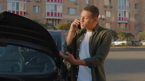 Young Adult Talking on Phone Next to Car
