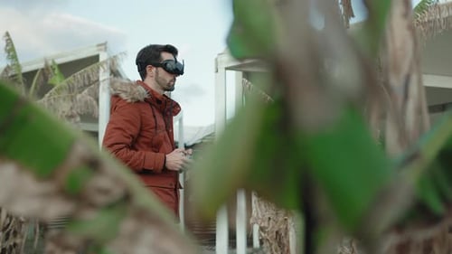 Young Adult Uses VR Headset in Tropical Setting