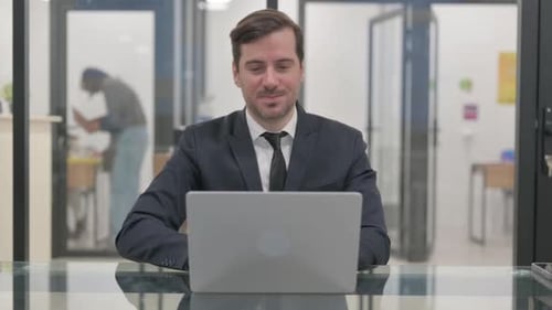 Man in Suit Video Calling in Modern Office