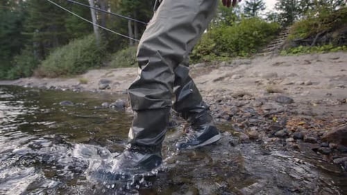 Fisherman walks into the river