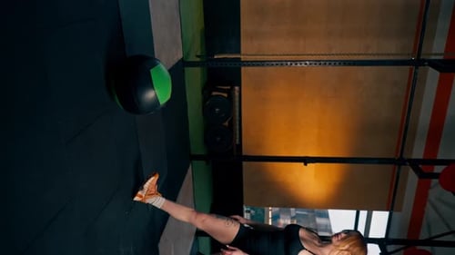 Vertical Video In the Gym Redhaired Girltrainer Approaches the Lying Ball Picks It Up and Leaves