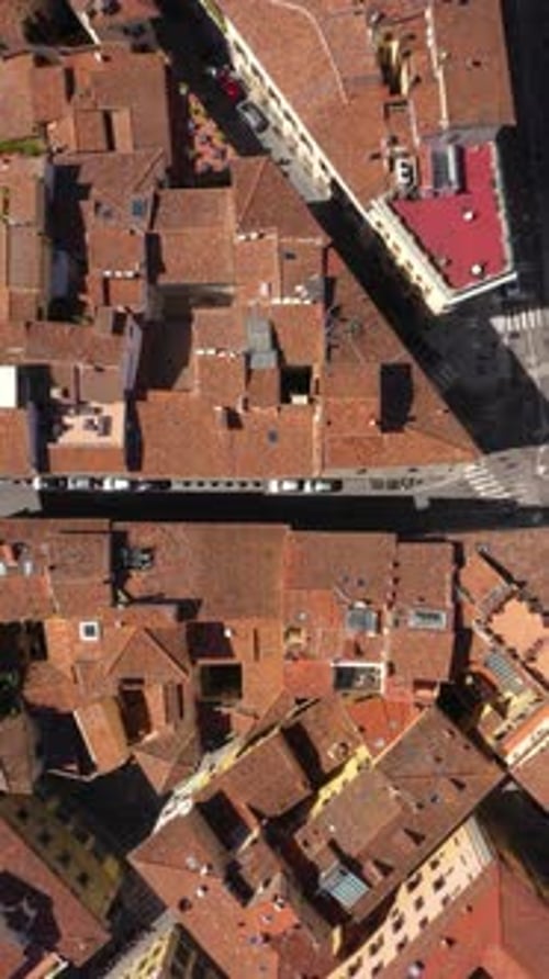 Vertical static top down view of roofs, roads and city on a sunny day in Florence in Italy.