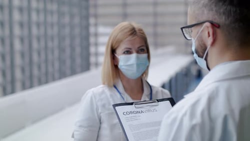 Doctors Discussing Coronavirus Report in Modern Hospital