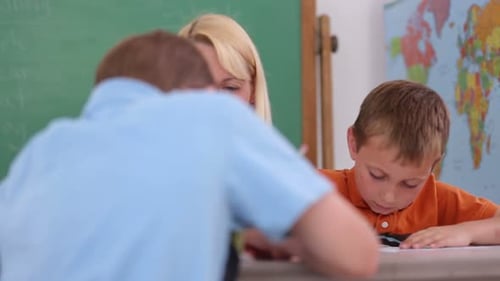 Teacher at School Helps Student with Writing 30s