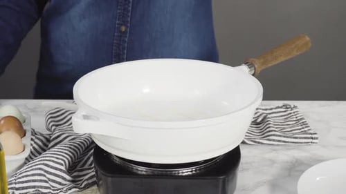Frying Farm Fresh Eggs in a White Skillet
