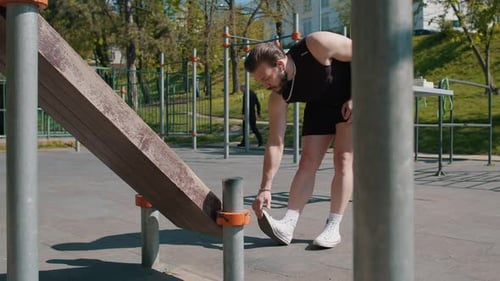 Athletic Man in Sportswear Stretching Legs Warm Up Body Before Cardio Workout Squatting Exercises