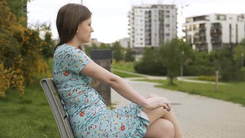 Woman Relaxing on a Park Bench in City