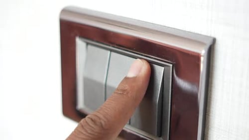 Um dedo ligando o interruptor de iluminação