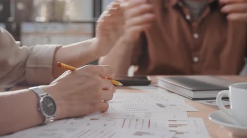 People Analyze Data Charts in a Meeting