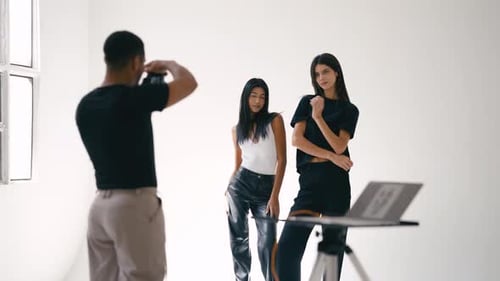 Photographer Taking Pictures of Two Fashion Models in Studio