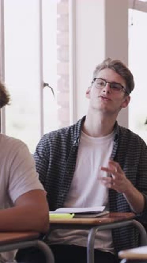 Teen Student Raises Hand and Participates in Class