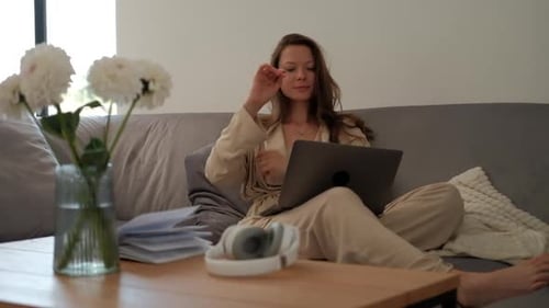 Woman Relaxing on Sofa With Laptop Indoors