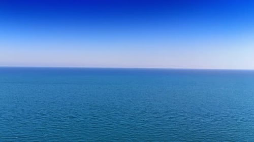 Weitläufiger Meerblick unter klarem blauem Himmel. Das Meer erstreckt sich endlos unter einem strahlend blauen Himmel