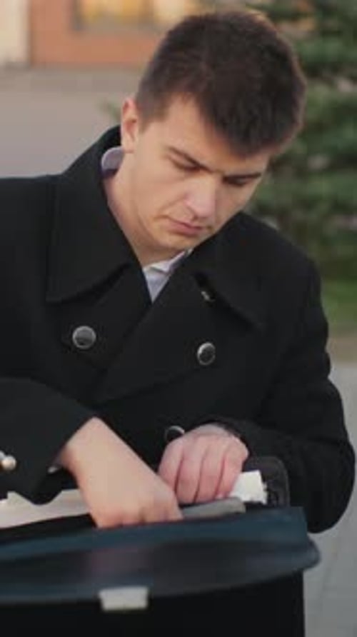 Young Adult Taking Tablet from Briefcase Outdoors