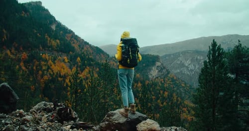 Woman Stand on Mountain Edge with Epic View at Autumn Cloudy Day on Travel