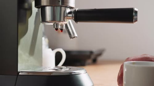 Espresso Machine Brewing Coffee into White Mug