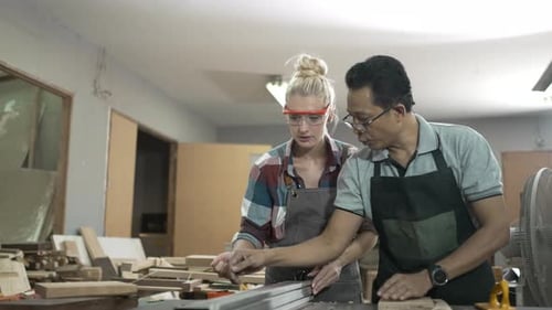 Carpenters are working together at workshop.