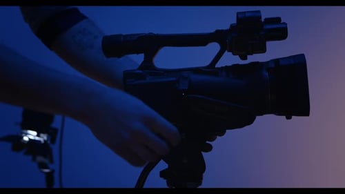 Hand Adjusting Professional Video Camera in Studio