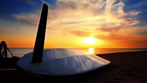 Surfboard Lying On The Beach At Sunset/Time Lapse/Sea Sunset/Surf On Beach At Sunset/Surfboard On...