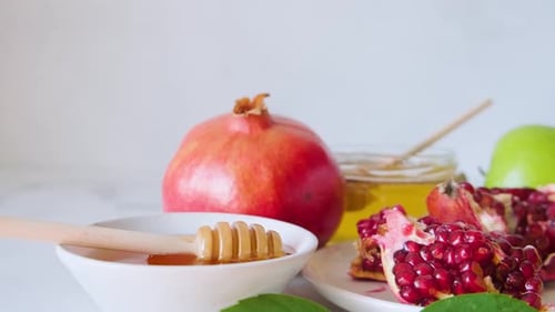 Comida festiva judía de Rosh Hashaná con miel, granada y manzanas sobre fondo blanco