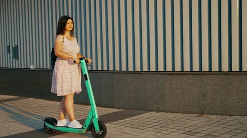 Young Woman on an Electric Scooter Having Fun Rides Through the City Streets