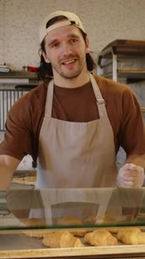 Bakery Worker Telling about Assortment of Pastry to Customer