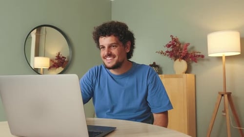 Young Adult Video Calling on Laptop at Home