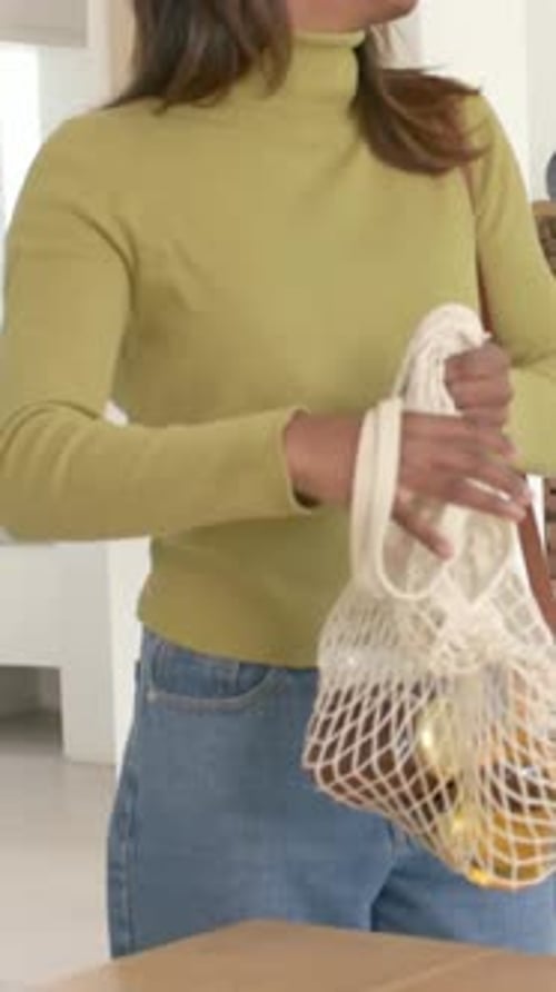 Vídeo vertical: correa de ajuste para mujer con la copa de oliva que pasa, bolsa de red con tarro de limones en casa, espacio para copiar