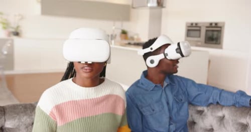 Couple Experiencing Virtual Reality Headsets at Home