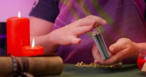 Close Up Shuffling Tarot Cards With Candles