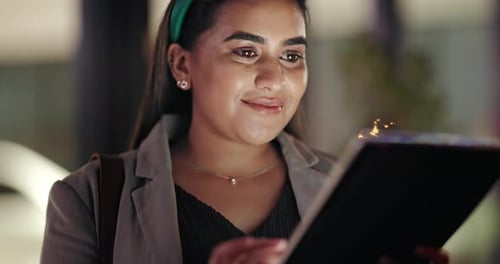 Woman Using Tablet at Night Smiling