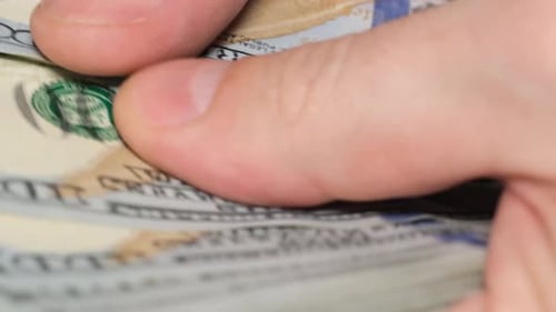 Hands Counting Stacks of Hundred Dollar Bills