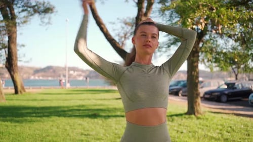 Woman Tying Hair in Park Before Workout