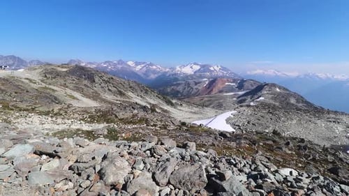 Point de vue pointant vers les pieds, puis soulevant la caméra montrant un vaste paysage, une chaîne de montagnes
