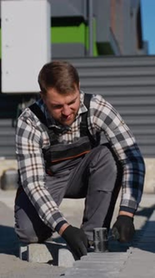 Construction Worker Laying Paving Stones in an Urban Setting