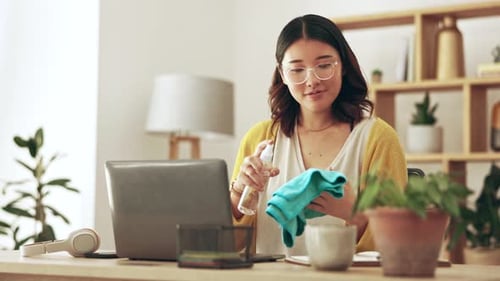 Woman Cleans Laptop with Disinfectant at Home