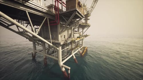 Old Oil Platform Stands Tall Above the Calm Ocean Waters During Sunset