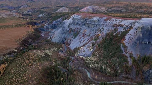River Along The Mountain Slopes With Trees In Wright Pass, Yukon, Canada. - aerial pullback shot